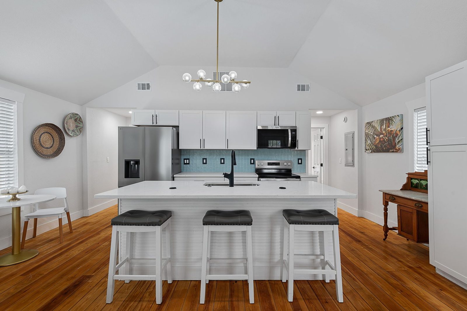 Renovated kitchen with quartz countertop island and coastal-blue backsplash